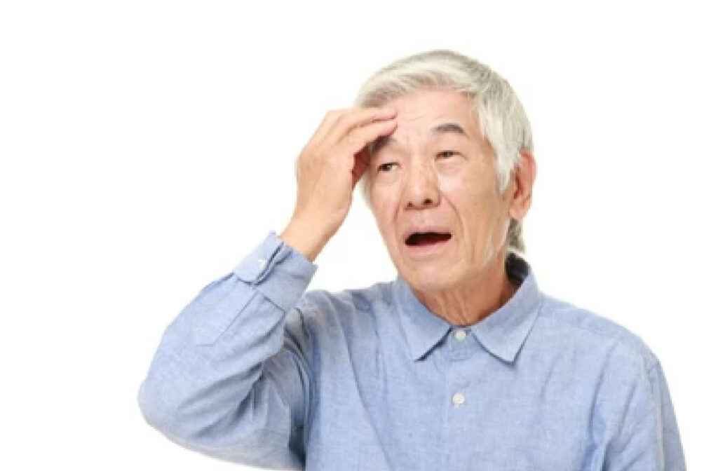 A senior male is touching his head with a gesture on his face of having a hard time remembering things.