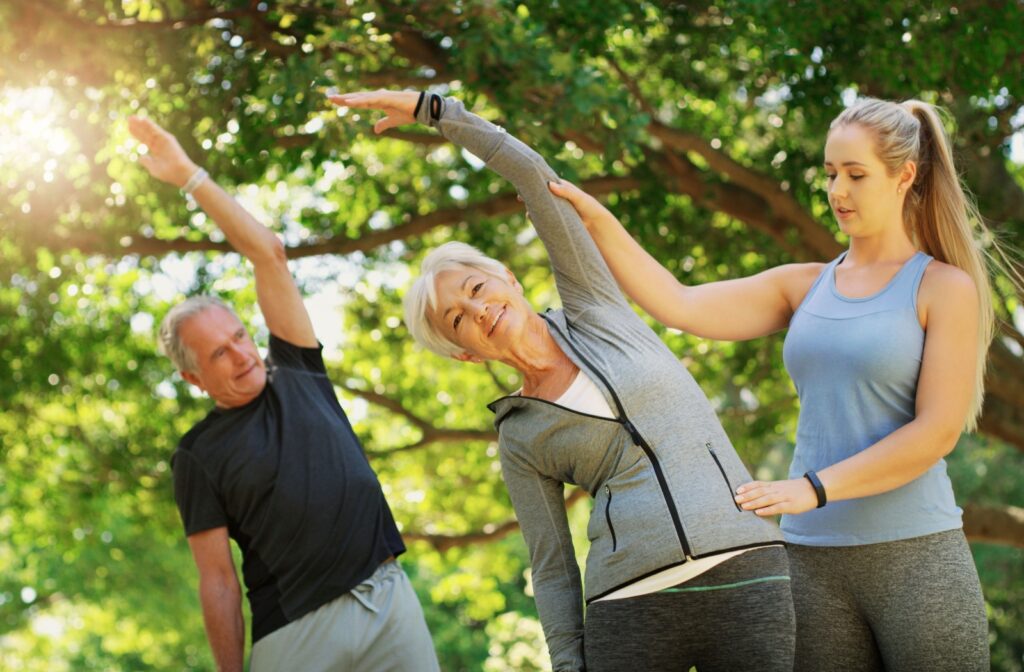 2 seniors participate in a yoga class and receive guidance from the instructor.