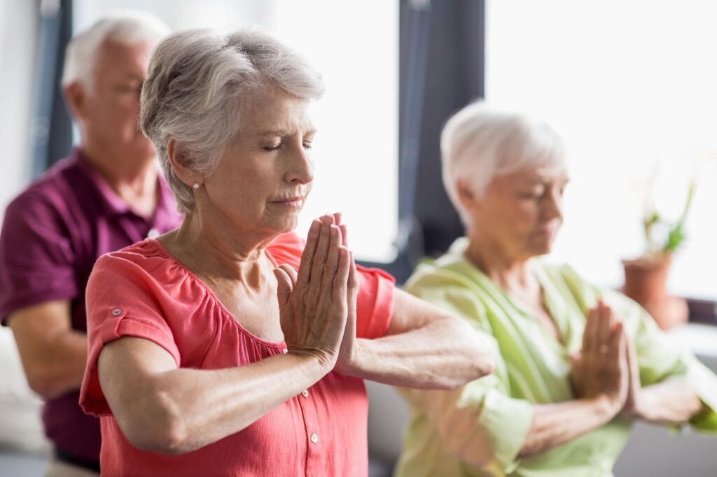 A group of senior adults practicing yoga together at a senior living community.