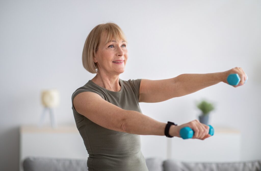 Mature woman lifting weights in front of her body.