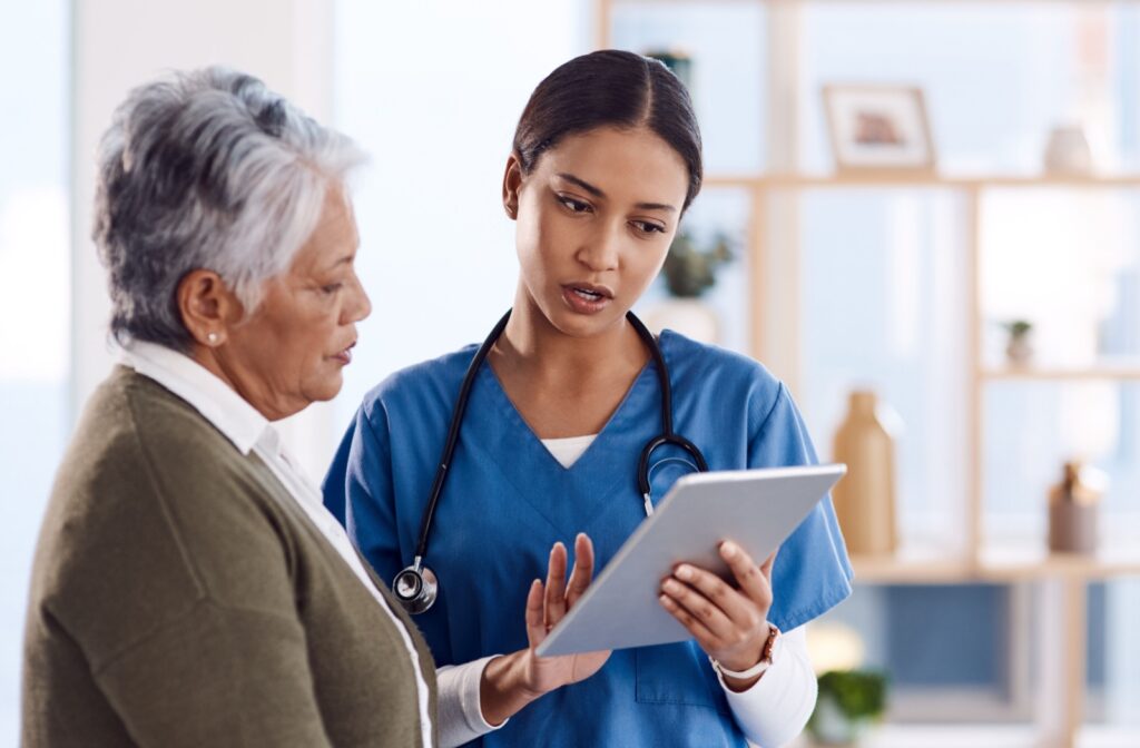 An older adult talking to a healthcare professional and reading from a tablet while discussing potential side effects of the keto diet.