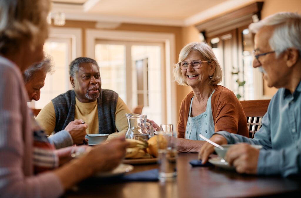 Group of seniors sharing a meal within the assisted living community.