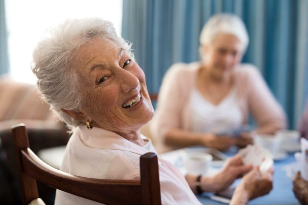 senior woman playing cards with her friends in independent living